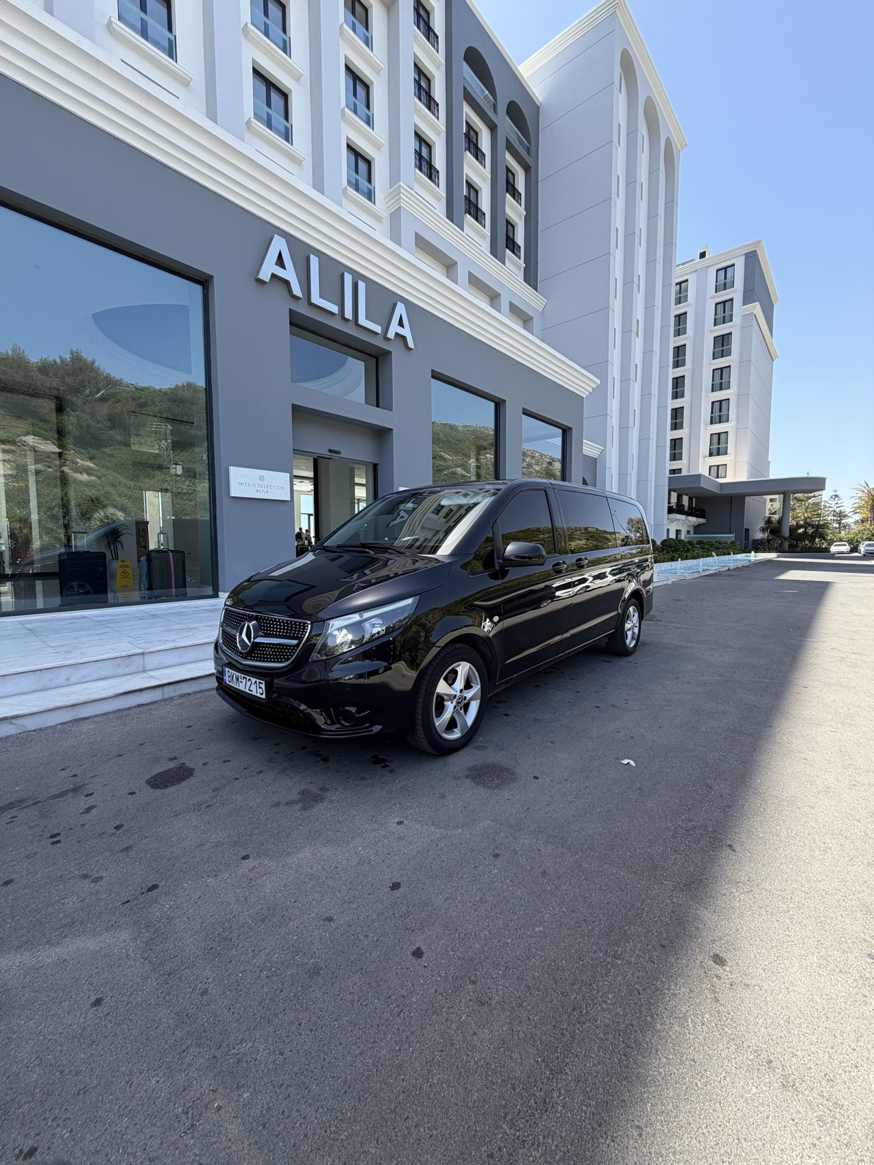 Black Mercedes van waiting at a hotel entrance on Rhodes