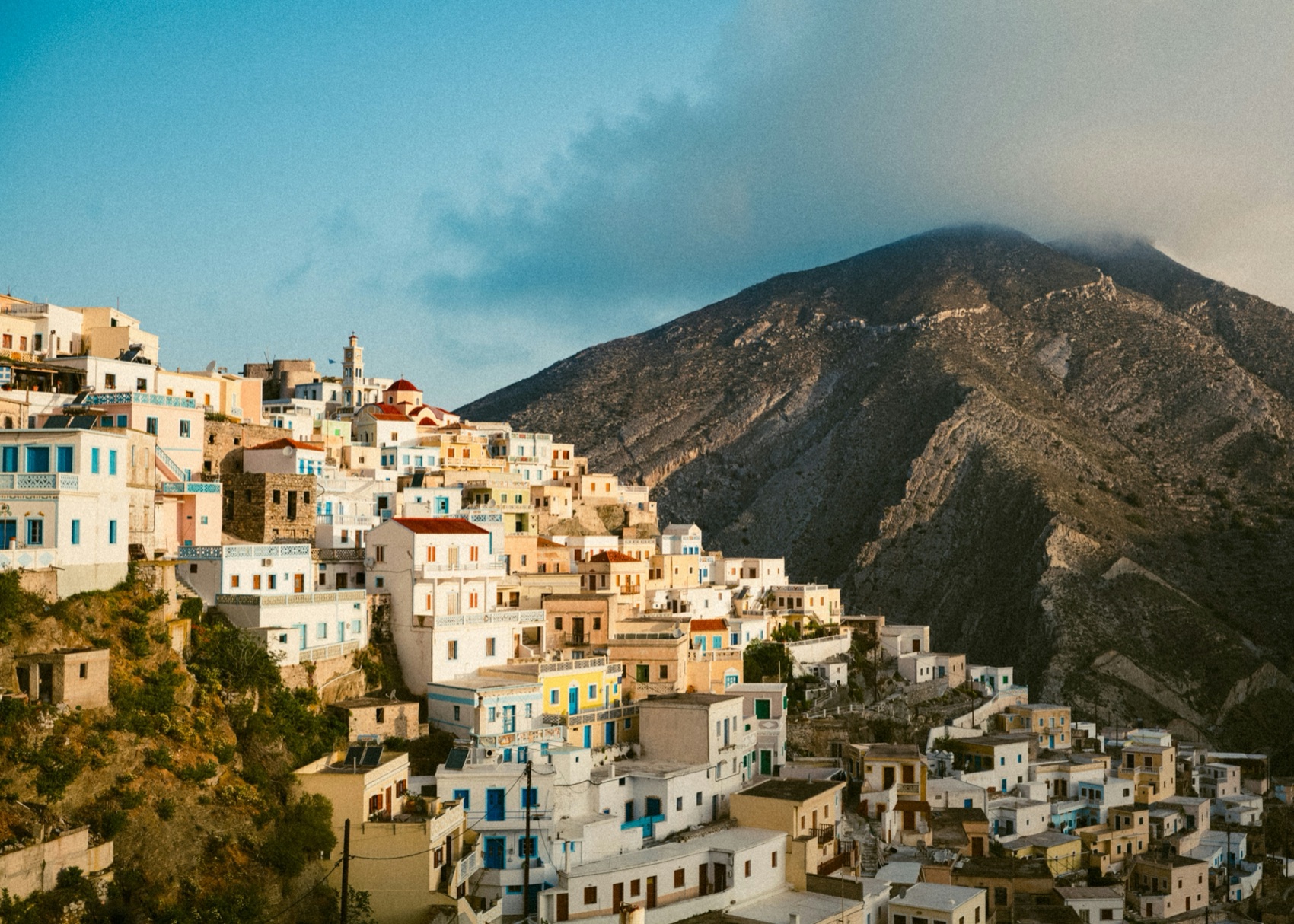 Painted houses stacked up a steep mountain slope in a traditional village