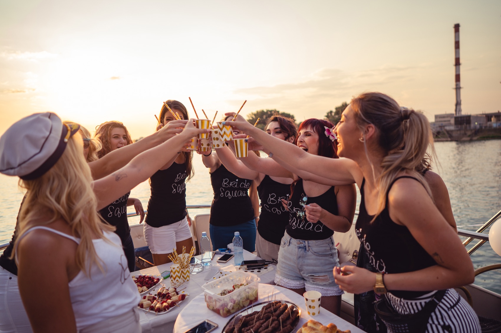 A group raising their glasses together against the evening light