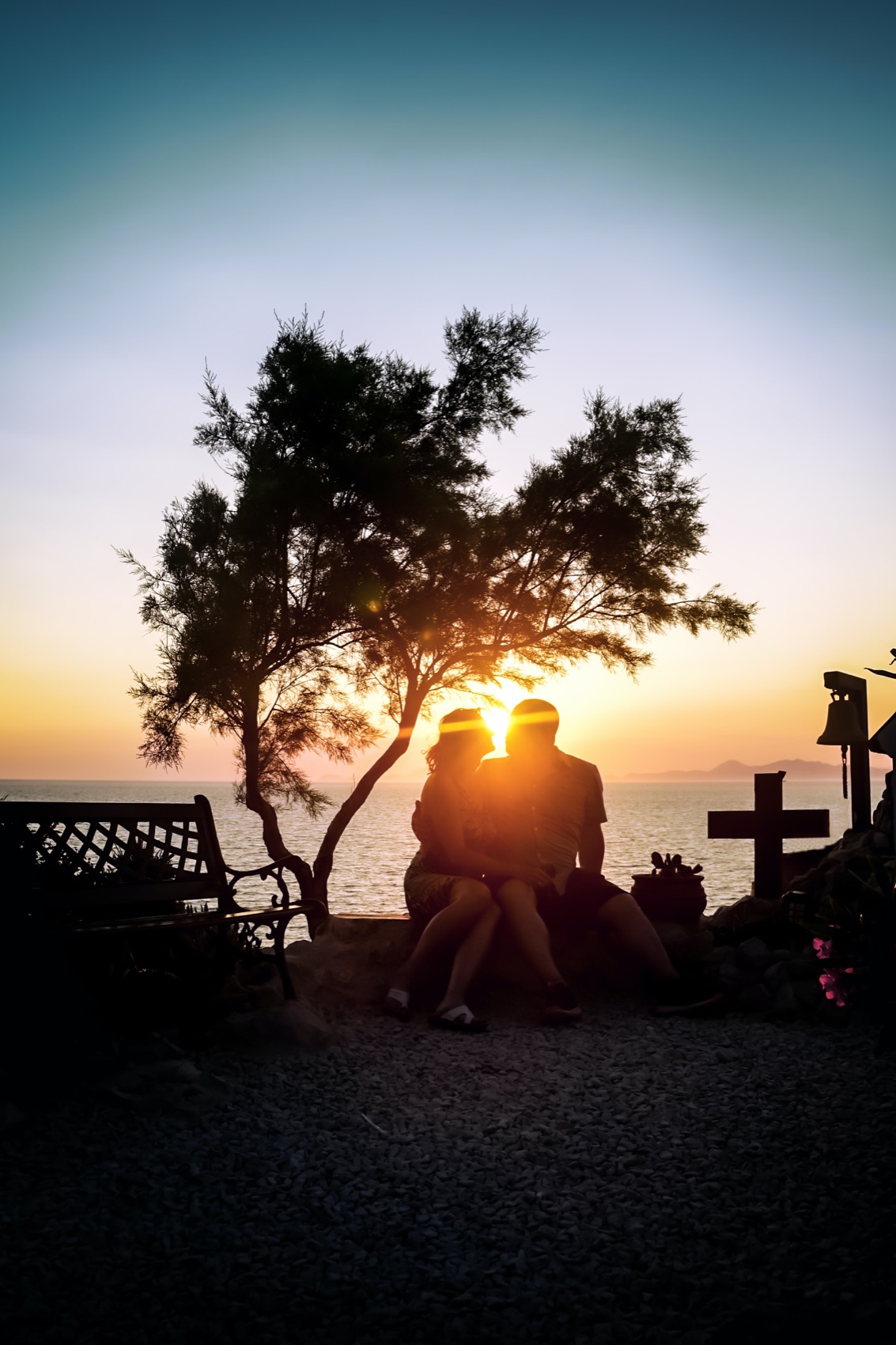 Silhouettes at a viewpoint as the sun goes down over the sea